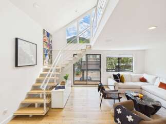 Experience modern living in this stunning home featuring a dramatic open-concept living area with soaring vaulted ceilings and expansive windows that flood the space with natural light.