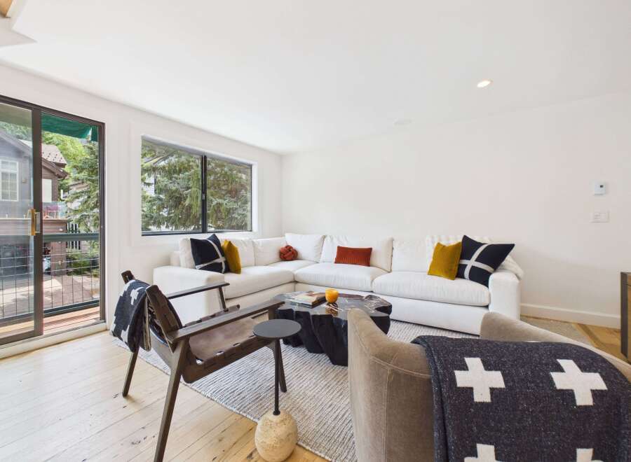 Experience modern living in this stylish living room featuring a spacious sectional sofa adorned with decorative pillows.