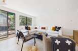 Experience modern living in this stylish living room featuring a spacious sectional sofa adorned with decorative pillows.