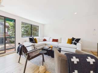 Experience modern living in this stylish living room featuring a spacious sectional sofa adorned with decorative pillows.