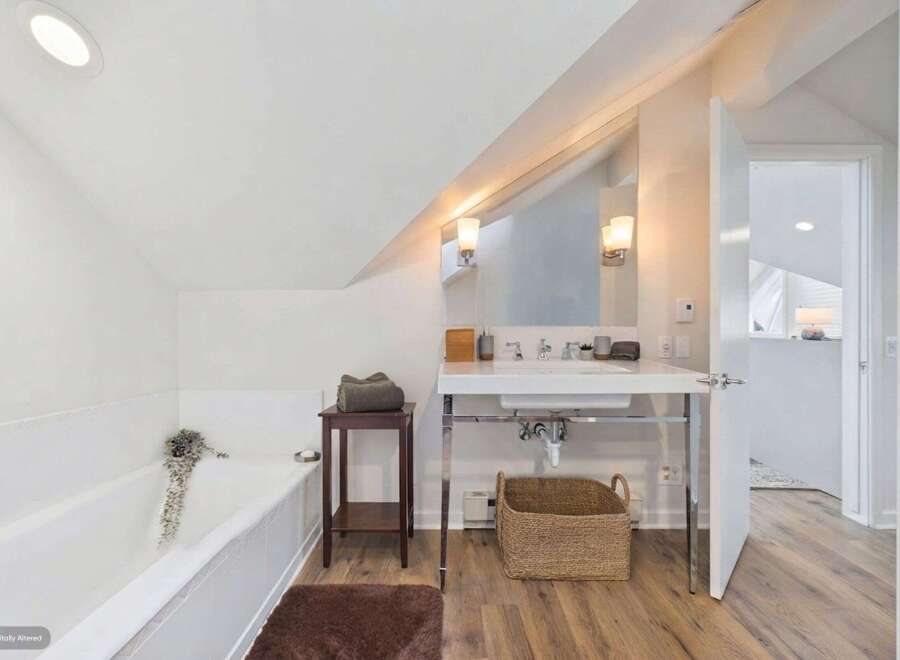 This bright and airy bathroom features a deep soaking tub perfect for relaxation, complemented by a sleek vanity with a modern vessel sink.
