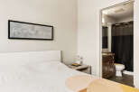 This inviting bedroom features a comfortable bed with a textured quilt and a modern white headboard.