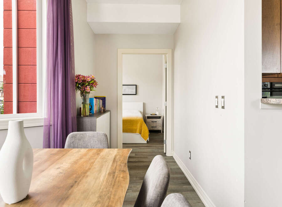 Experience modern living in this beautifully appointed home, featuring a spacious dining area with a stylish vase and comfortable seating.