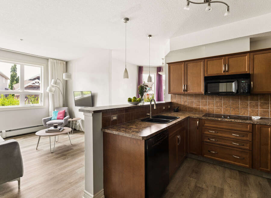 Discover this inviting open-concept living space, seamlessly blending a modern kitchen with a cozy living area.