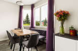 Brighten your dining experience in this charming space, featuring a rustic wooden table perfect for family meals.