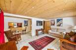 Experience cozy living in this charming mountain retreat, featuring a warm wooden ceiling and a spacious living area.