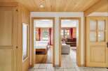 Step into a charming alpine retreat featuring a cozy living area with a plush sofa and a separate bedroom with two inviting beds.