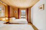 Experience cozy mountain living in this charming bedroom featuring two comfortable beds, perfect for families or friends.