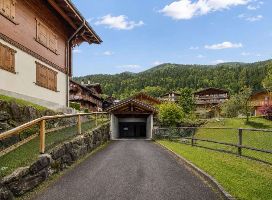 Discover this charming alpine village nestled amidst lush green mountains, featuring traditional wooden chalets with beautiful balconies and shutters.