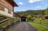 Discover this charming alpine village nestled amidst lush green mountains, featuring traditional wooden chalets with beautiful balconies and shutters.