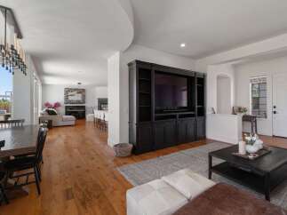 This spacious open-concept living area features a large entertainment center with a flat-screen TV, perfect for movie nights.