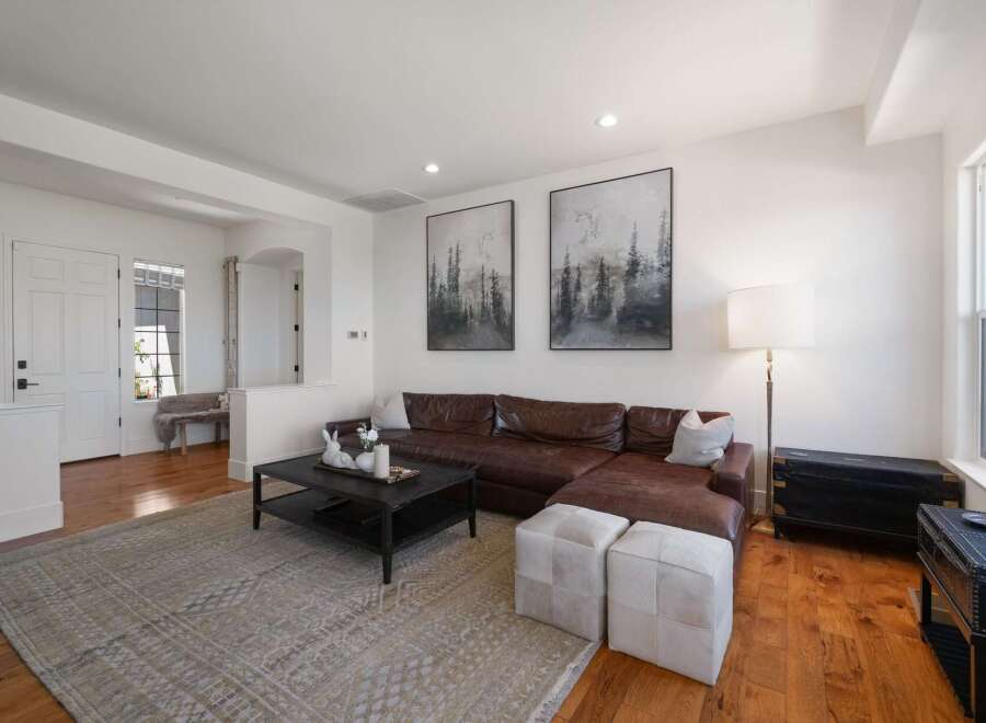 This spacious living room features a luxurious brown leather sectional sofa, perfect for relaxing and entertaining.
