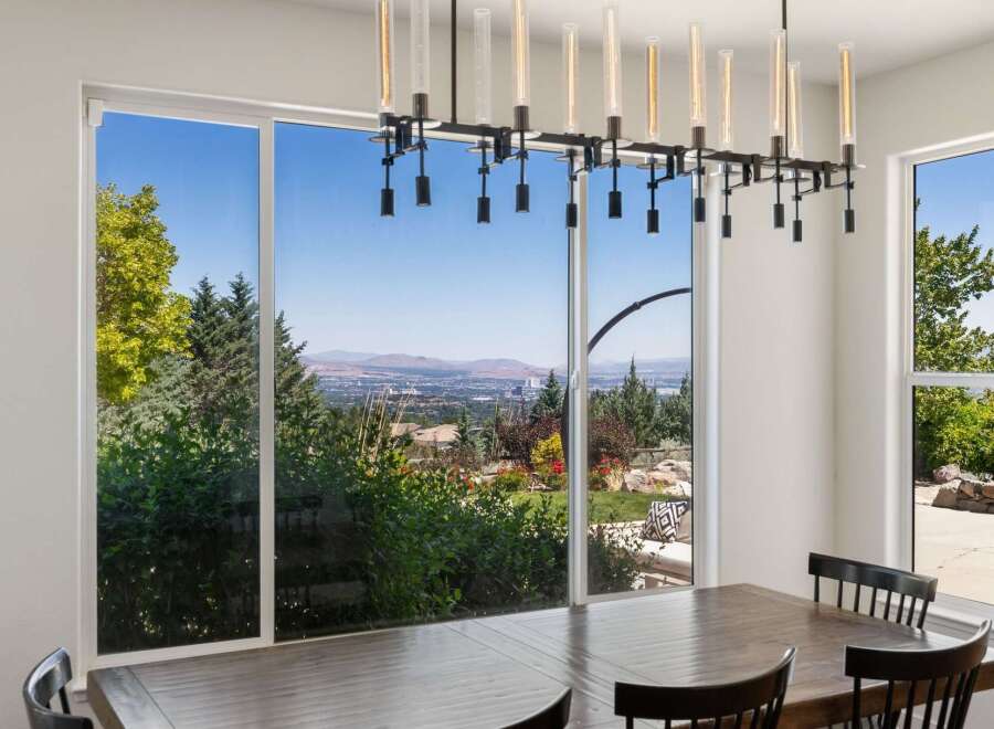 Experience breathtaking panoramic views from this stunning dining room, featuring expansive windows that showcase a vibrant landscape.