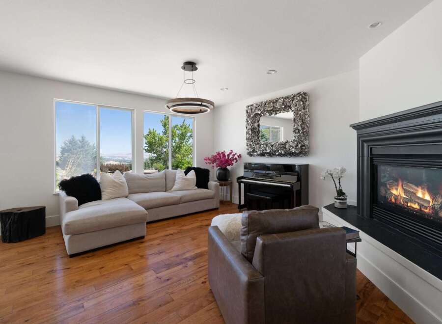 Experience luxury living in this stunning home featuring a spacious sectional sofa, elegant grand piano, and a cozy fireplace.