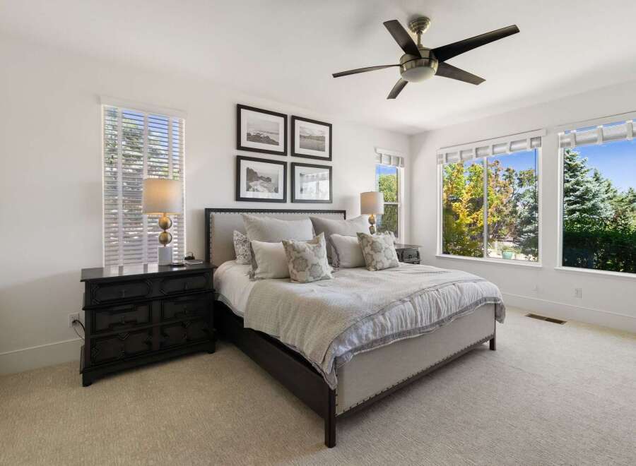 Experience ultimate comfort in this beautifully appointed bedroom, featuring a plush king-size bed adorned with decorative pillows and a cozy throw.