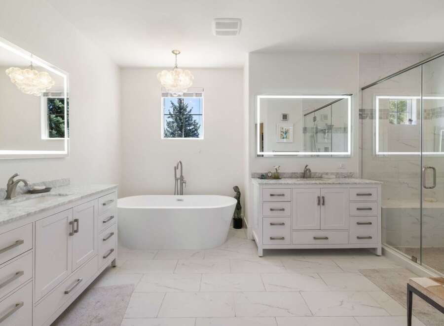 Experience luxury in this stunning modern bathroom featuring a freestanding soaking tub and a spacious glass-enclosed shower.
