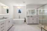Experience luxury in this stunning modern bathroom featuring a freestanding soaking tub and a spacious glass-enclosed shower.
