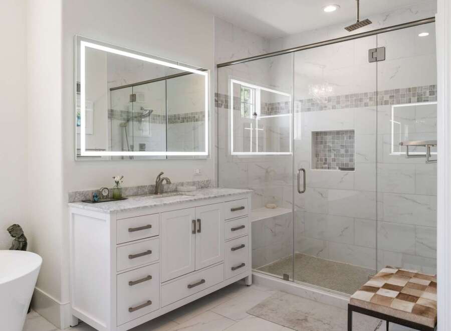 Experience luxury in this modern bathroom featuring a spacious walk-in shower with elegant marble tile and a built-in bench.