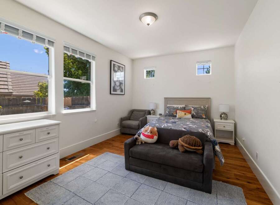 This charming bedroom features a comfortable queen-size bed with playful bedding, perfect for a child or guest room.
