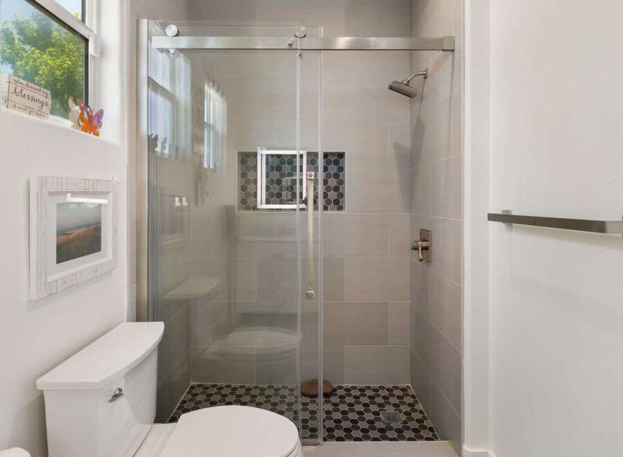 Experience modern comfort in this beautifully appointed bathroom, featuring a sleek glass-enclosed shower with elegant tile work and a convenient built-in niche.