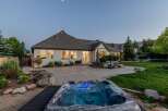Experience ultimate relaxation in this stunning backyard oasis, featuring a luxurious hot tub perfect for unwinding under the evening sky.