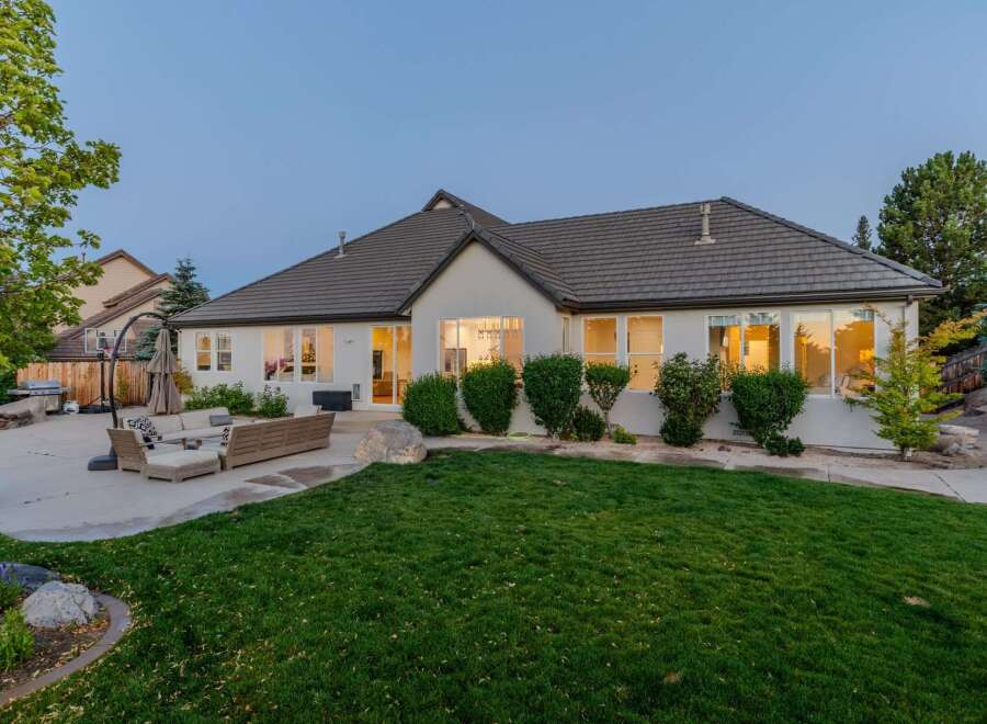 This stunning single-story home boasts a spacious backyard perfect for entertaining, featuring a large patio with comfortable outdoor seating and a built-in grill.