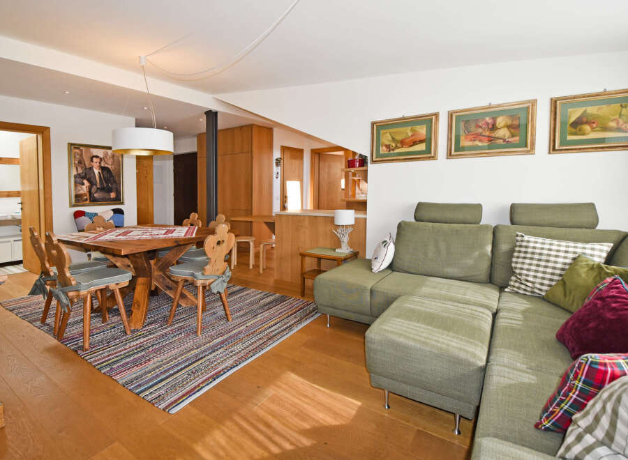 Experience cozy living in this charming dining and living area, featuring a rustic wooden dining table with traditional chairs perfect for family meals.