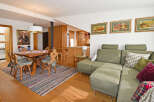 Experience cozy living in this charming dining and living area, featuring a rustic wooden dining table with traditional chairs perfect for family meals.