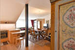 Discover this charming apartment featuring a cozy living area with a comfortable sofa and a rustic dining set perfect for family meals.