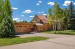 Experience rustic charm in this stunning log home, featuring a spacious attached garage and a welcoming covered entryway.