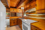 Step into this charming log cabin kitchen, featuring warm wooden cabinetry and countertops that complement the rustic log walls.