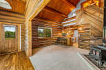 Experience rustic charm in this cozy log cabin featuring a spacious living area with a warm fireplace and a convenient breakfast bar.