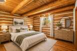 Experience rustic charm in this cozy log cabin bedroom, featuring a comfortable bed adorned with plush pillows and a soft green throw.