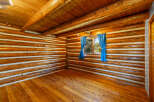 Experience rustic charm in this log cabin interior, featuring warm wooden floors and a striking log wall construction.