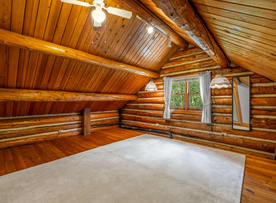 Experience rustic charm in this cozy log cabin loft, featuring warm wooden interiors and exposed beams.