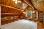 Experience rustic charm in this cozy log cabin loft, featuring warm wooden interiors and exposed beams.