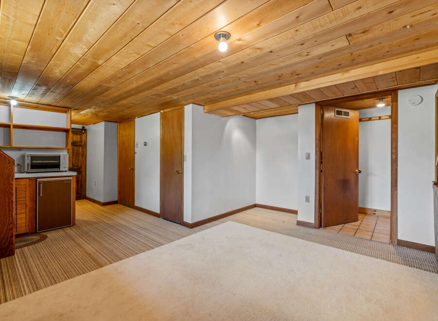 Discover versatile living spaces with this charming room featuring a convenient kitchenette area complete with a microwave and mini-fridge.