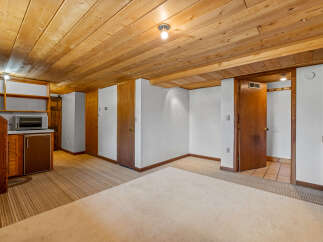 Discover versatile living spaces with this charming room featuring a convenient kitchenette area complete with a microwave and mini-fridge.