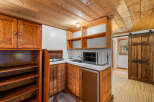 Discover this charming kitchenette featuring warm wooden cabinetry and a convenient countertop space.