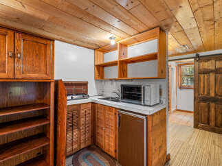 Discover this charming kitchenette featuring warm wooden cabinetry and a convenient countertop space.