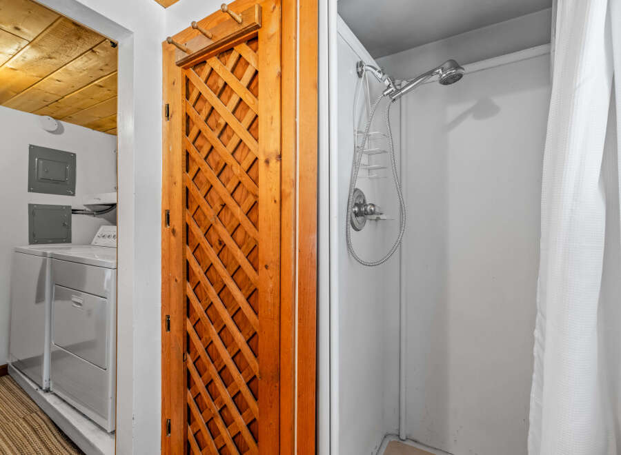 Discover convenience with this laundry area featuring a washer and dryer, adjacent to a charming wooden lattice door.