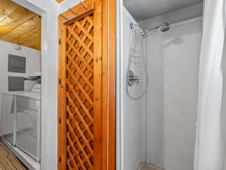Discover convenience with this laundry area featuring a washer and dryer, adjacent to a charming wooden lattice door.