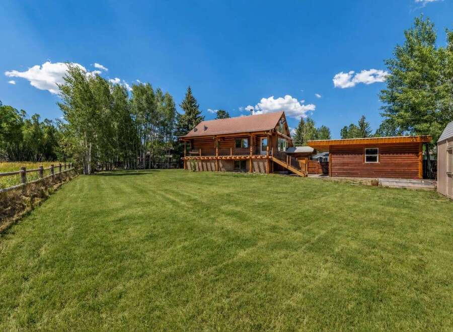 Experience rustic charm in this beautiful log home, nestled amidst mature trees and featuring a spacious wrap-around deck perfect for outdoor entertaining.