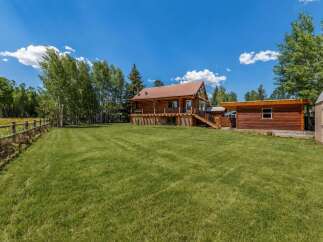 Experience rustic charm in this beautiful log home, nestled amidst mature trees and featuring a spacious wrap-around deck perfect for outdoor entertaining.