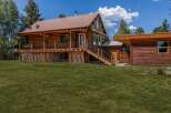 Experience rustic charm in this beautiful log cabin home, featuring a spacious wrap-around porch perfect for enjoying the serene surroundings.
