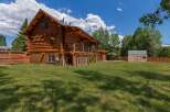 Experience rustic charm in this stunning log cabin, featuring a spacious covered porch perfect for enjoying the outdoors.