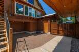 Discover this charming property featuring a rustic wooden exterior and a welcoming paved patio area.