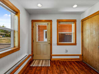 Step into this charming entryway featuring warm wooden accents and a durable, attractive hardwood floor.