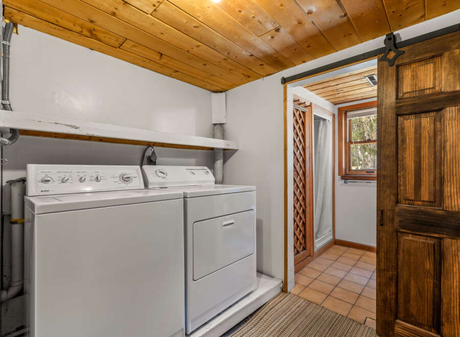 This laundry room features a stacked white washer and dryer, perfect for maximizing space.