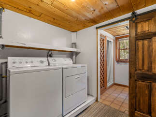 This laundry room features a stacked white washer and dryer, perfect for maximizing space.
